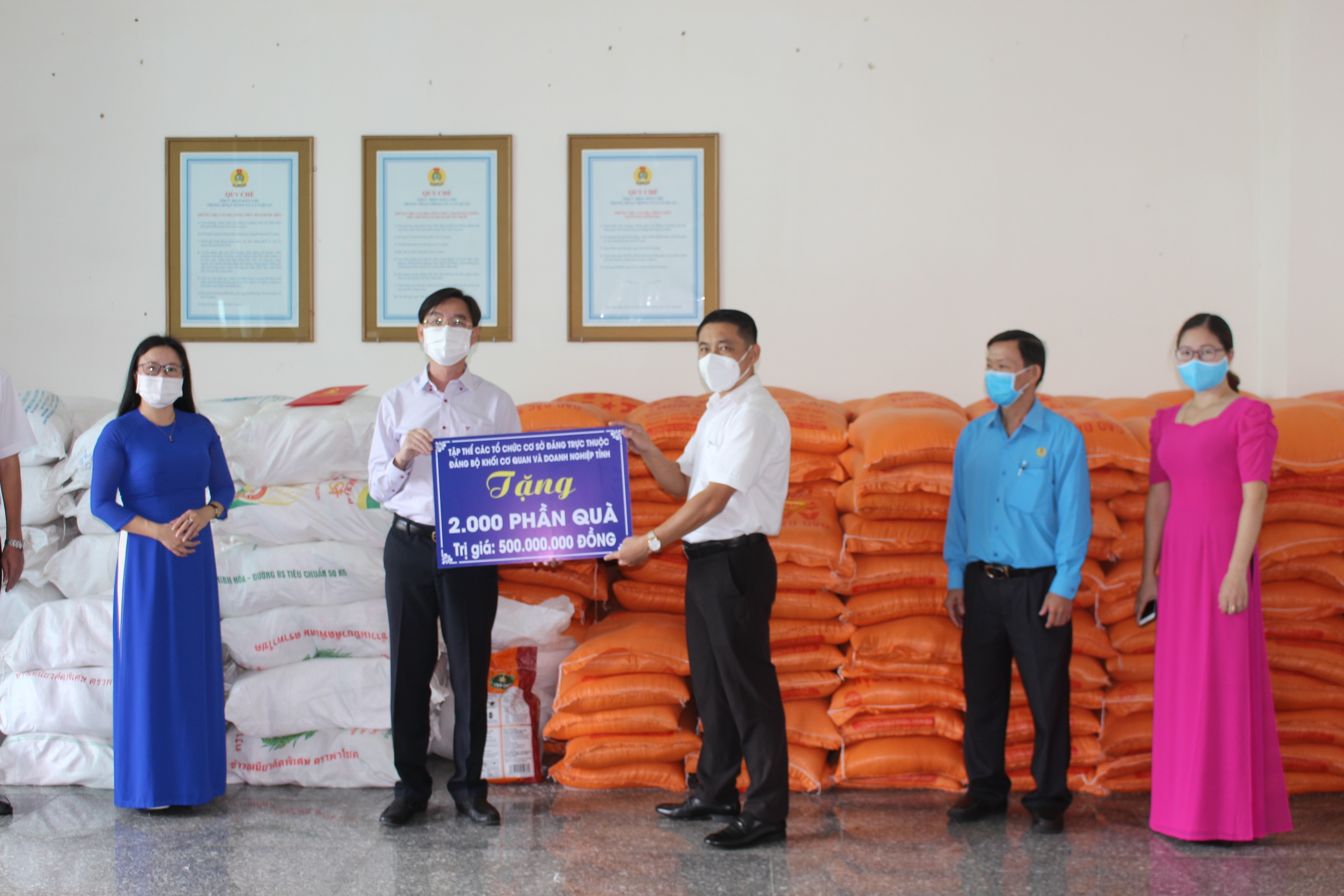 Ông Huỳnh Sơn Tuấn - Chủ tịch LĐLĐ tỉnh tiếp nhận bảng tượng trưng 2.000 phần quà từ ông Nguyễn Trường Giang.