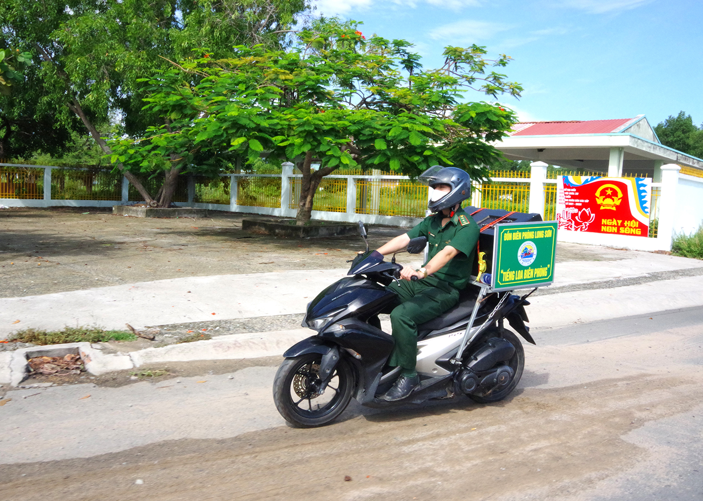 Cán bộ Đội Vận động quần chúng Đồn Biên phòng Long Sơn chở loa đi tuyên truyền về phòng chống dịch COVID-19.