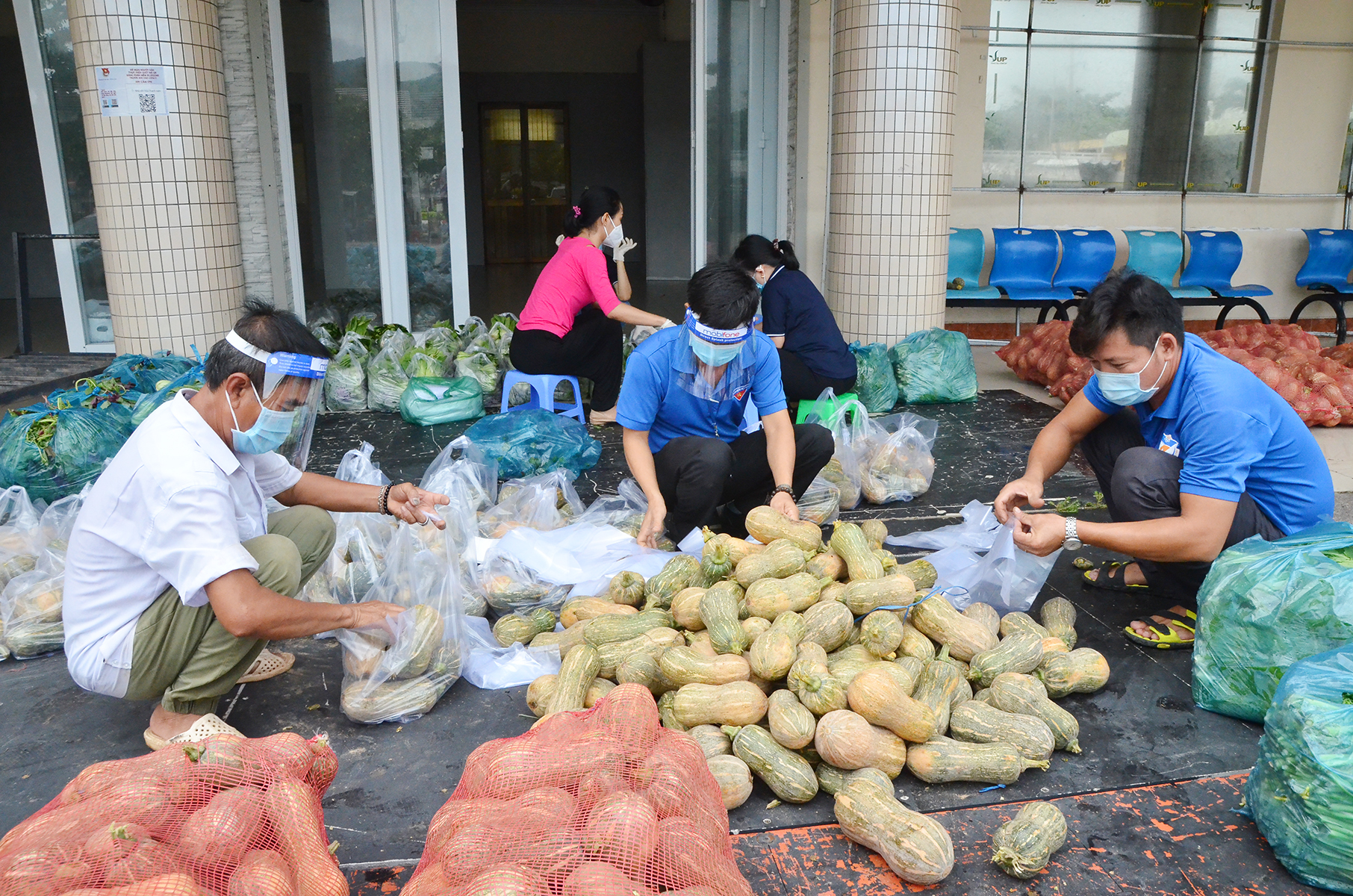 Cán bộ, nhân viên Nhà Văn hóa Thanh niên chia các phần rau, củ ặng các bếp ăn và người dân trong khu phong tỏa. Ảnh: MINH QUANG