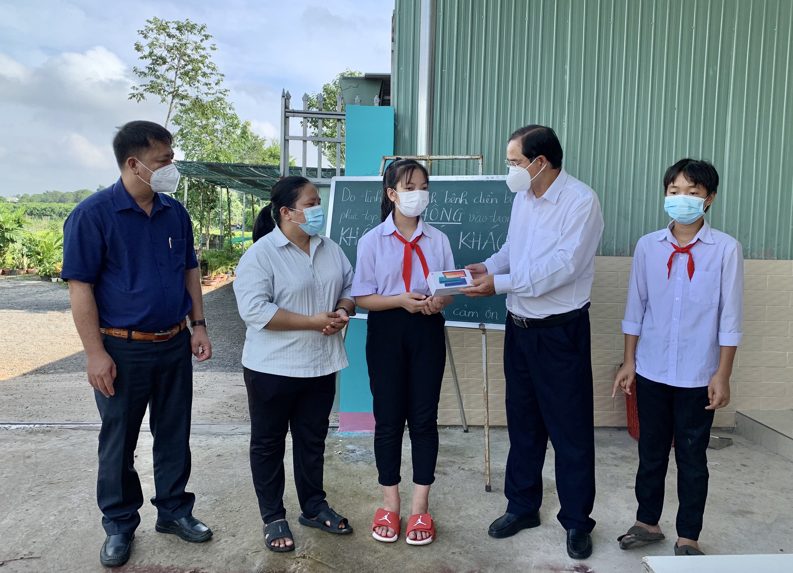 Ông Nguyễn Tấn Bản, Phó Bí thư Thường trực Huyện ủy Châu Đức trao điện thoại thông minh cho em Nguyễn Uyên Nhi (HS lớp 7A3, Trường THCS Võ Trường Toản).