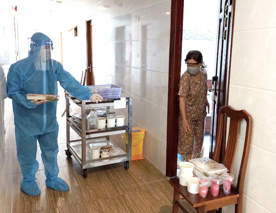 Nhân viên khách sạn Cao Su hướng dẫn khách lưu trú nhận suất ăn tại cửa phòng.