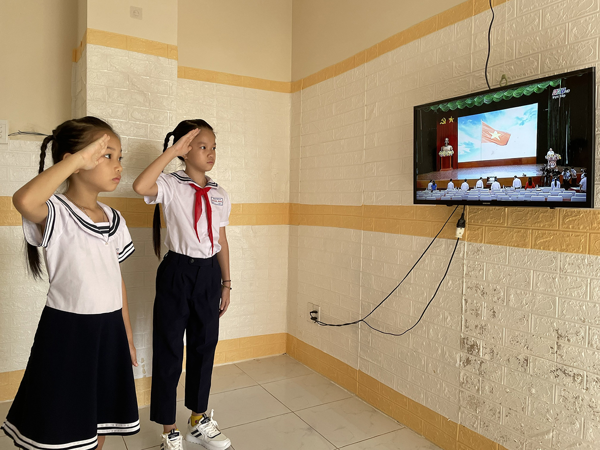 Hai chị em Trần Bảo Châu, HS lớp 5 và Trần Bảo Ngân, HS lớp 2 Trường TH Cao Văn Ngọc, huyện Côn Đảo dự Lễ khai giảng năm học 2021-2022 trực tiếp trên truyền hình. Ảnh: MẠNH CƯỜNG