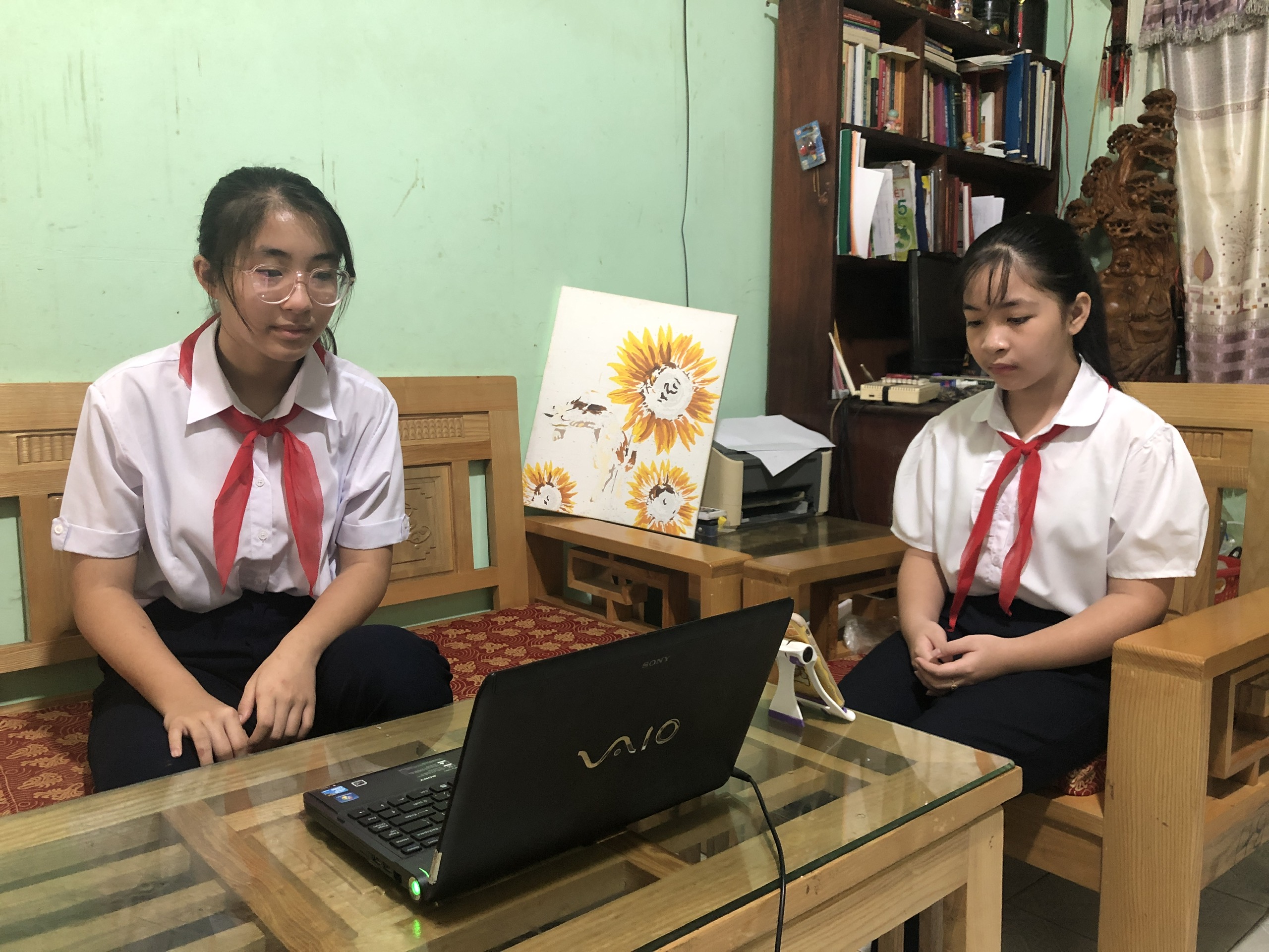 HS Lê Xuân Khánh Ngân (lớp 7, Trường THCS Lê Hồng Phong) và Lê Xuân Khánh Hà (lớp 5, Trường TH Cao Văn Ngọc, huyện Côn Đảo) dự lễ khai giảng trực tuyến năm học 2021-2022 tại nhà qua laptop. Ảnh: NGUYỄN CƯỜNG