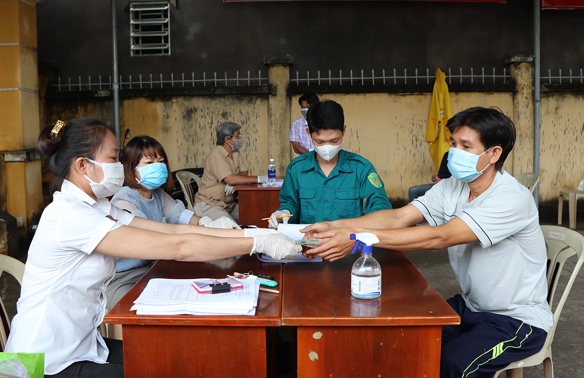 Bà Võ Thị Kiều Hoanh, cán bộ phụ trách công tác TBXH UBND xã Nghĩa Thành chi số tiền 1,5 triệu đồng cho ông Nguyễn Duy Linh (tổ 2, đường 23, thôn Vinh Sơn, xã Nghĩa Thành) - lao động bị ảnh hưởng bởi dịch COVID-19.