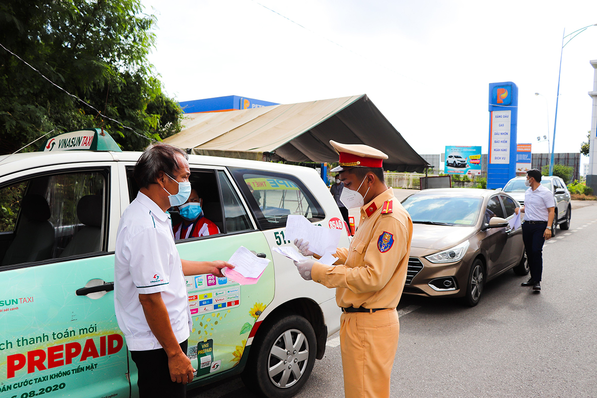 Lực lượng CSGT Công an huyện Long Điền (tại Chốt kiểm dịch huyện Long Điền) kiểm tra giấy tờ đi đường của một tài xế lưu thông trên QL55 hướng vào địa bàn huyện. Ảnh: ĐINH HÙNG