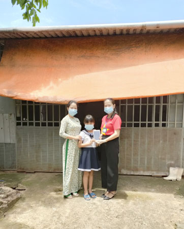 Cô Phạm Thị Tố Duyên (bìa trái), Chủ tịch Công đoàn trường và cô Đỗ Thị Thu An, GV Trường TH Phước Thắng trao tặng em Vương Thị Thủy Ngân chiếc máy tính bảng được mạnh thường quân hỗ trợ.
