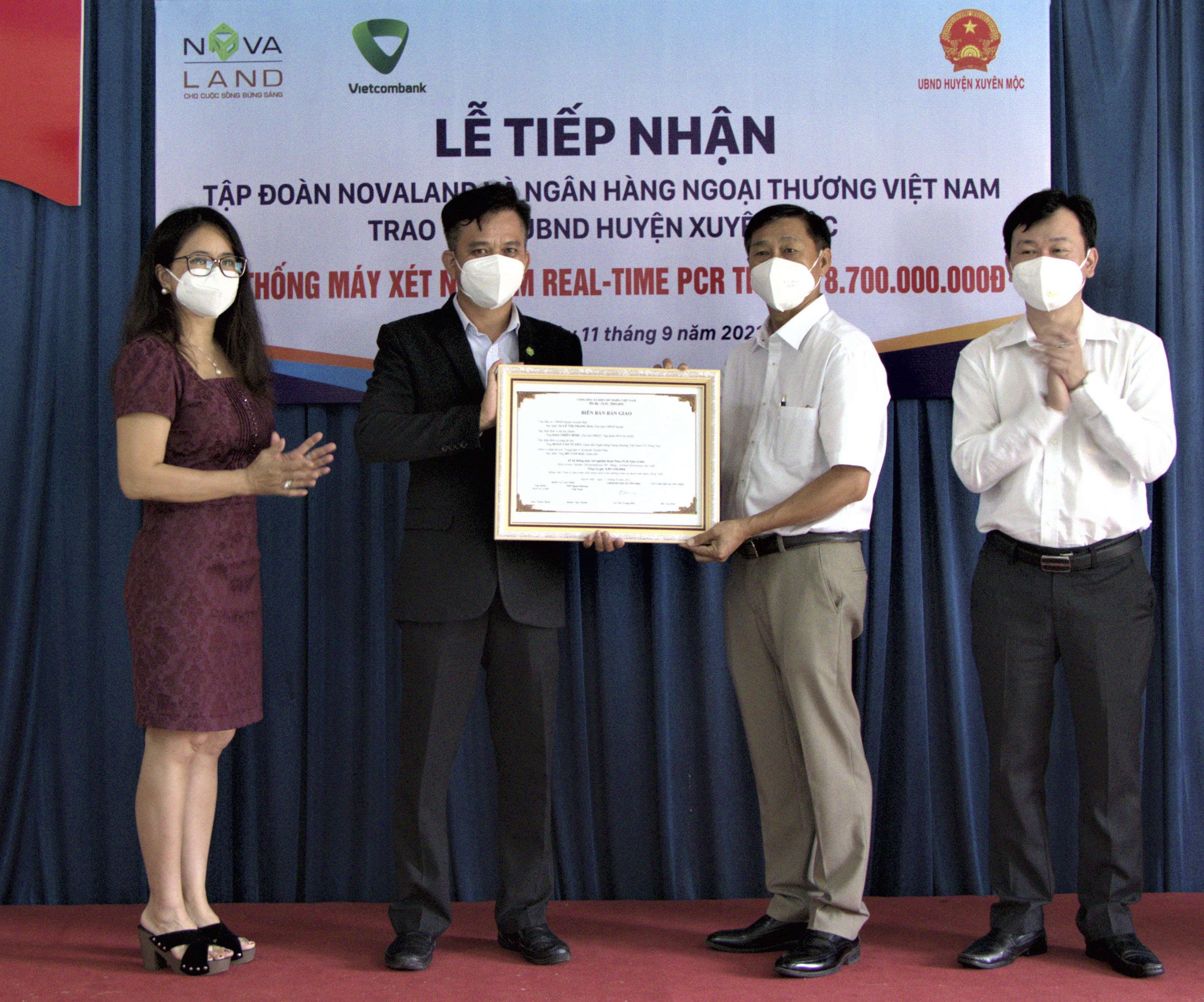 Bà Lê Thị Trang Đài (bìa trái), Chủ tịch UBND huyện Xuyên Mộc; ông Phạm Thành Chung (bìa phải), Bí thư Huyện ủy Xuyên Mộc tại lễ bàn giao hệ thống máy xét nghiệm Real-time PCR. 