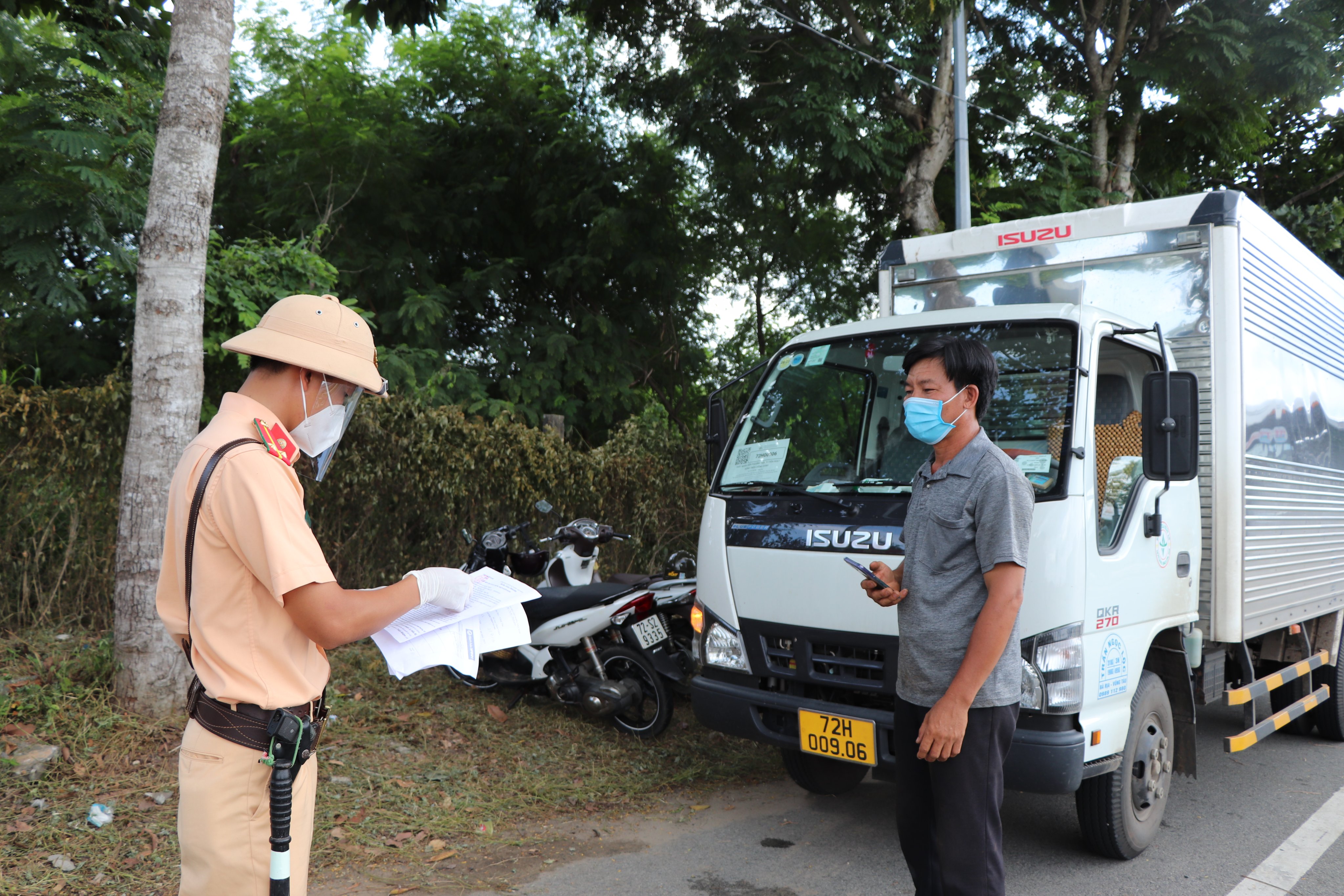CSGT - Công an huyện Long Điền kiểm tra giấy đi đường của tài xế xe tải khi lưu thông qua Chốt kiểm soát dịch trên QL55 (vòng xoay Vũng Vằn). ẢNH ĐINH HÙNG