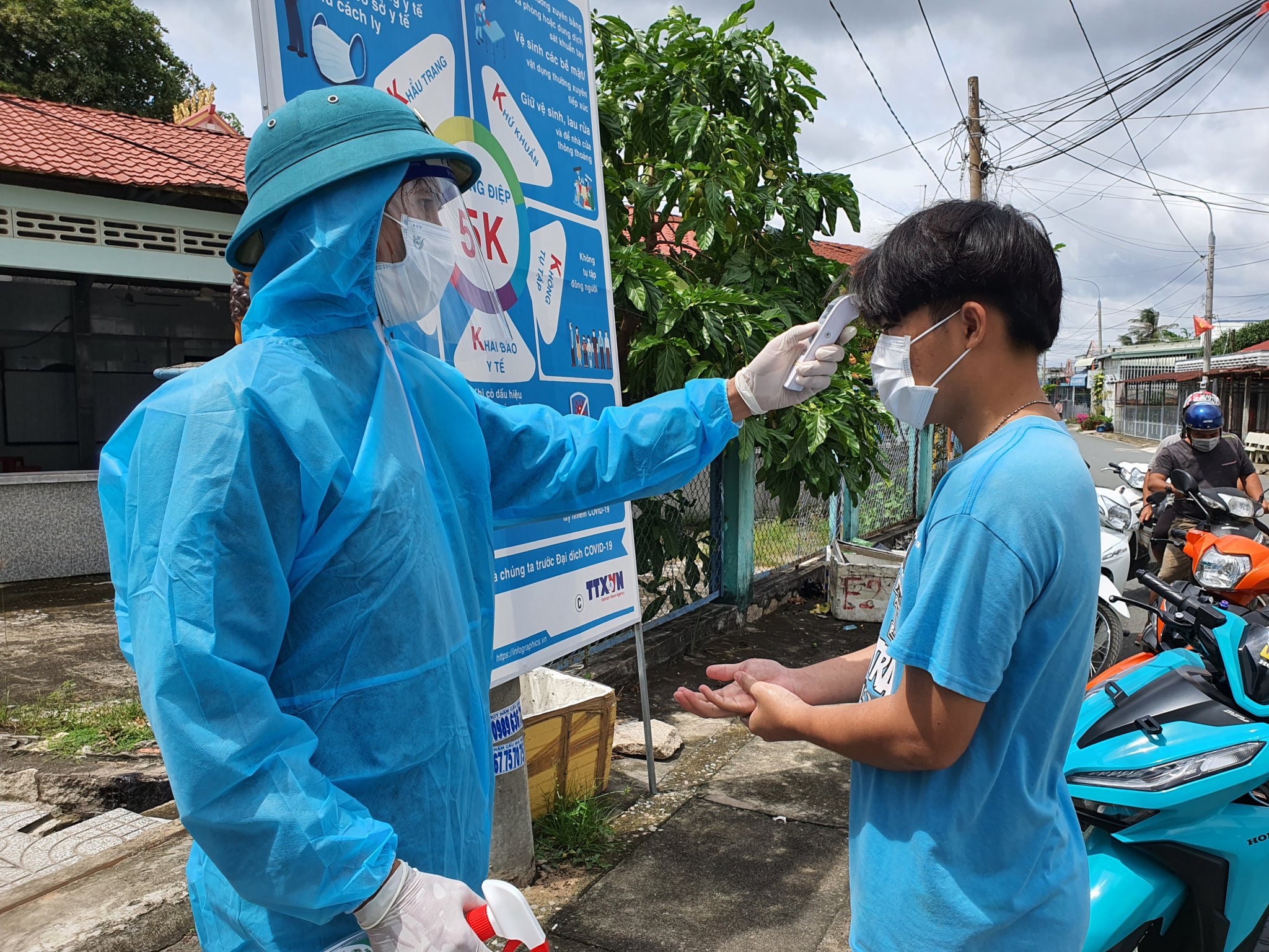 Lực lượng chức năng kiểm tra thân nhiệt của người dân xã Tân Hòa, TX. Phú Mỹ trước khi vào xét nghiệm. Ảnh MINH TÂM