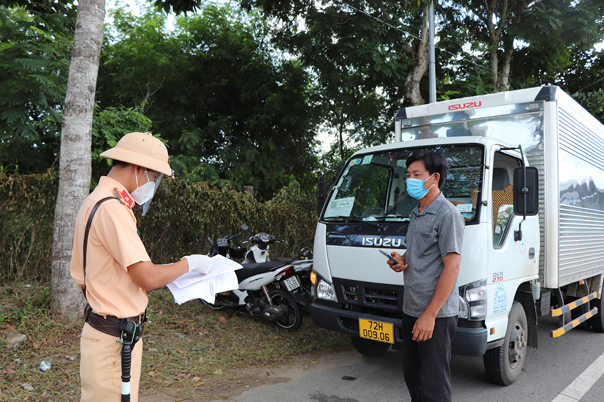 CSGT Công an huyện Long Điền kiểm tra giấy đi đường của tài xế xe tải tại Chốt kiểm soát dịch trên QL55 (vòng xoay Vũng Vằn). Ảnh: ĐINH HÙNG
