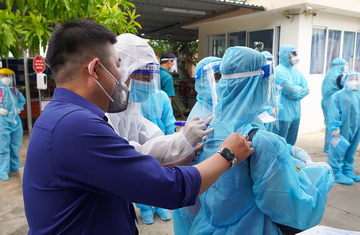 Nhân viên y tế ghi tên đồng nghiệp của mình trên chiếc áo bảo hộ để thuận tiện trong công tác phối hợp lấy mẫu xét nghiệm.