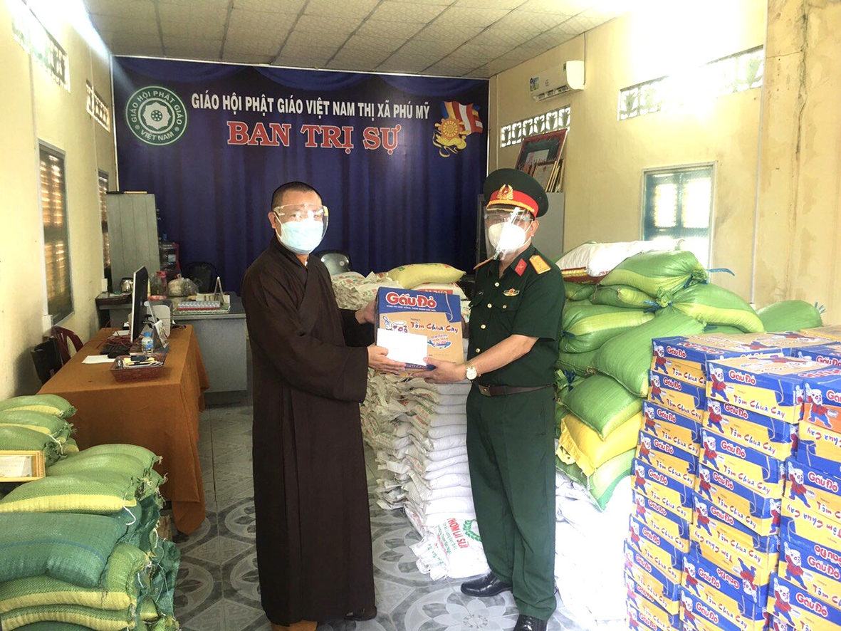 Đại đức Thích Nguyên Thái, Phó Ban Trị sự GHPG tỉnh, Phó Trưởng Ban Trường trực Ban Trị sự GHPG TX. Phú Mỹ trao quà và tiền cho đại diện Ban CHQS TX.Phú Mỹ.