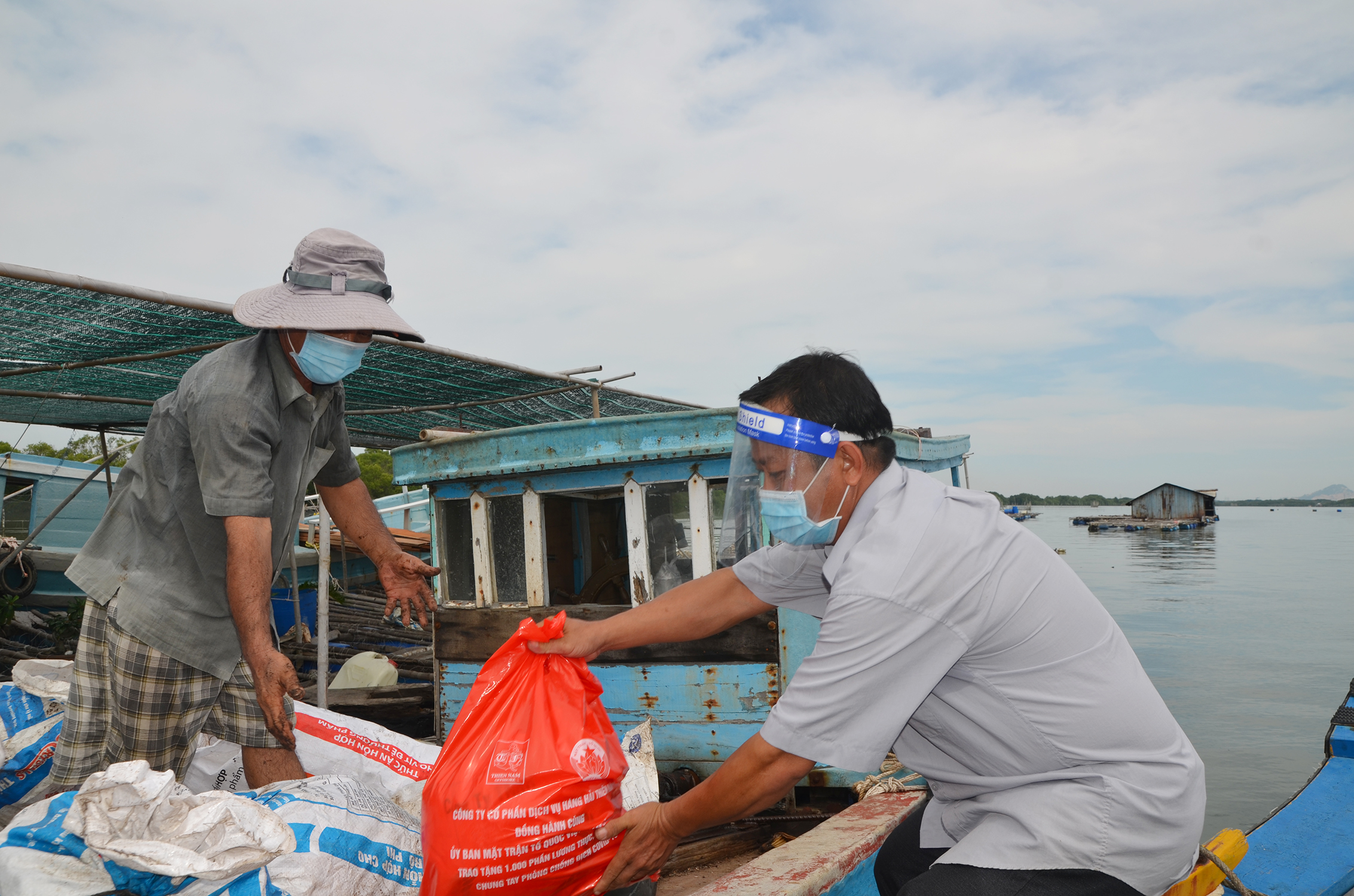Ông Mai Chí Trung, Phó Chủ tịch UBMTTQ Việt Nam xã Long Sơn tặng quà hộ dân sinh sống trên các bè nuôi thủy sản.