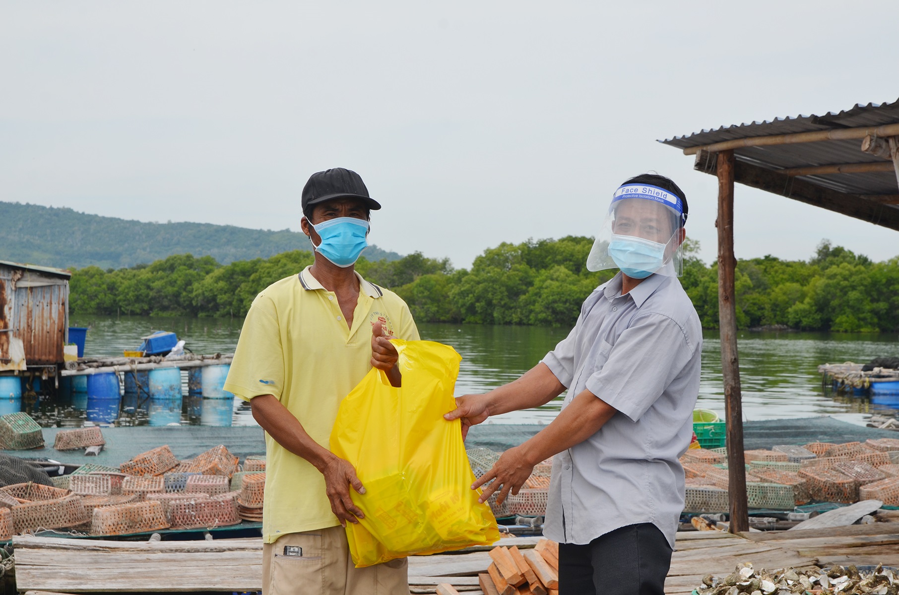 Ông Mai Chí Trung, Phó Chủ tịch UBMTTQ Việt Nam xã Long Sơn tặng quà hỗ trợ người dân  trên bè nuôi thủy sản.