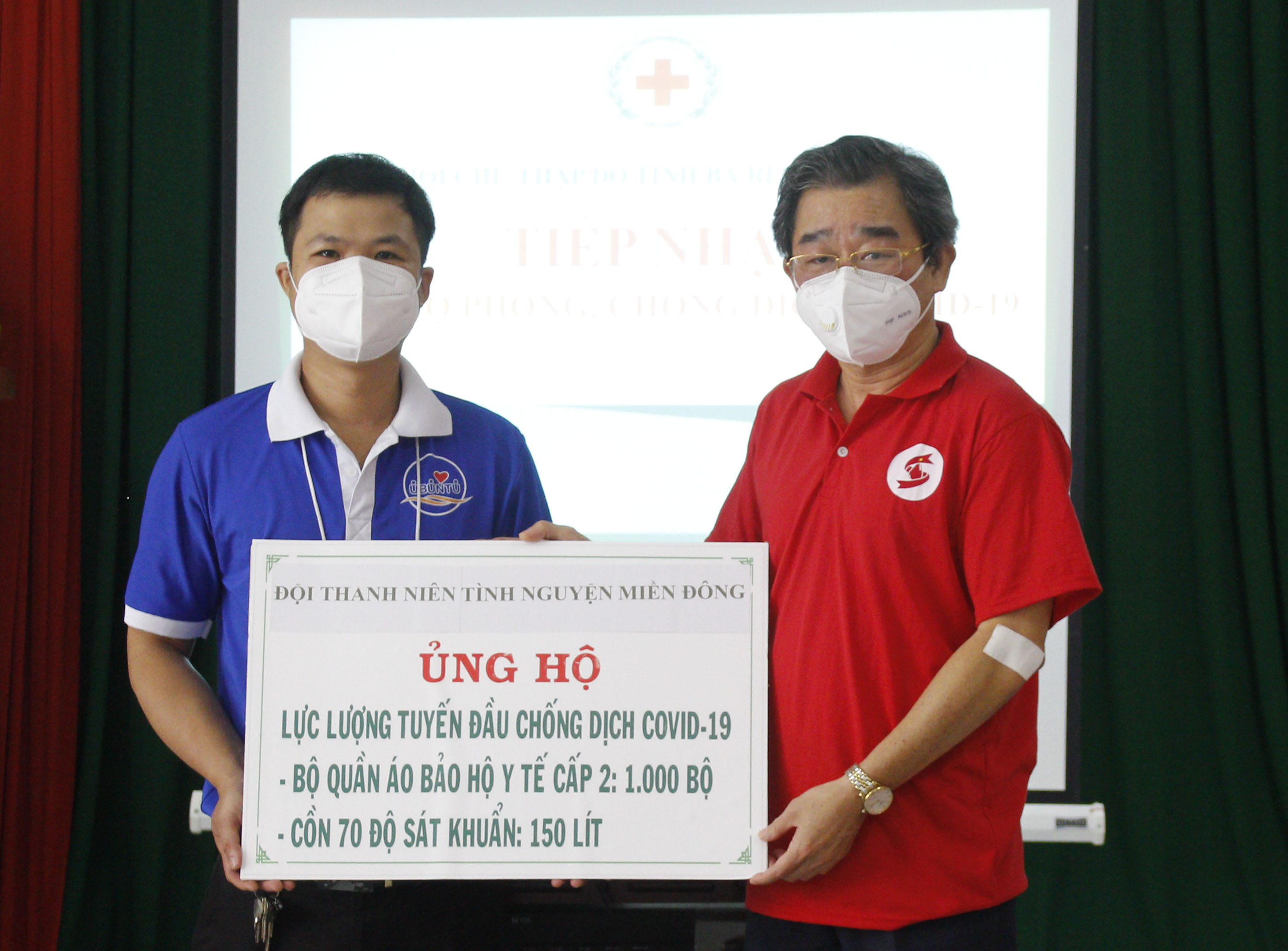 Ông Lê Văn Hậu, Chủ tịch Hội Chữ thập đỏ tiếp nhận bảng tượng trưng số vật tư y tế từ Đội Thanh niên tình nguyện Miền Đông.
