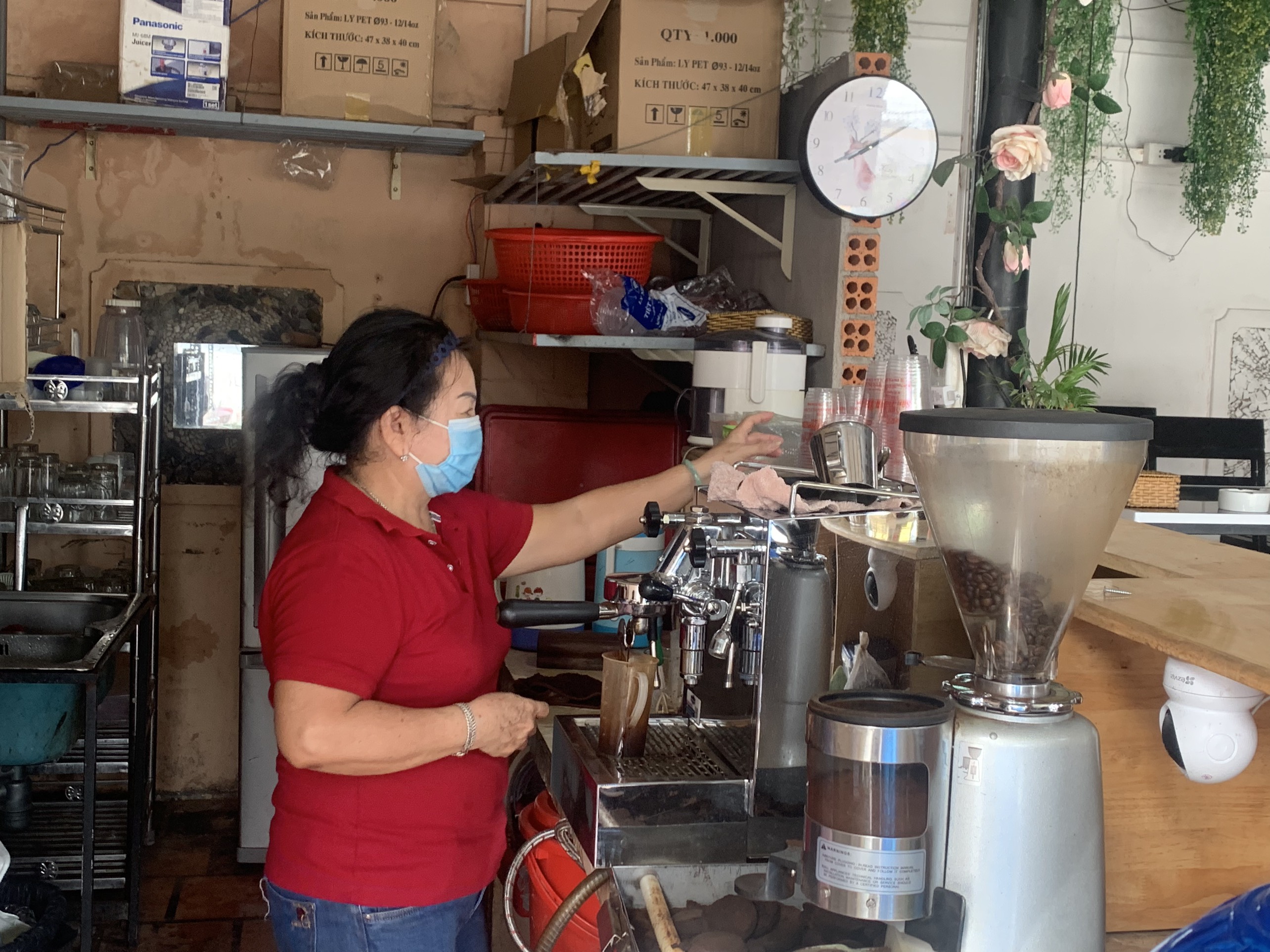 Một số quán cà phê nhỏ bán mang về đã mở cửa phục vụ khách. Trong ảnh: Chị Hoàng Thị Nga, chủ quán cà phê Sân Thượng pha cà phê cho khách.
