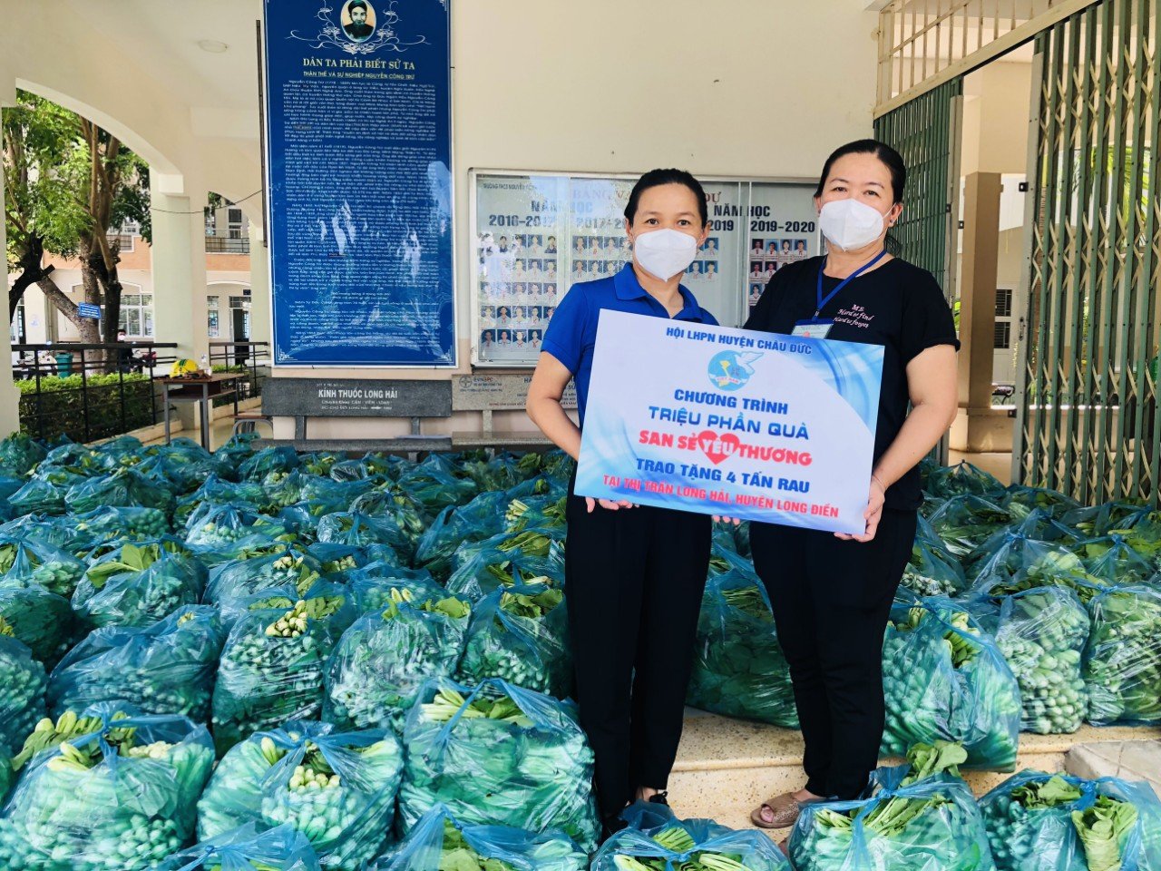 Bà Bùi Thị Sen (bên trái), Chủ tịch Hội LHPN huyện Châu Đức trao tặng rau cải xanh hỗ trợ người dân TT. Long Hải, huyện Long Điền.