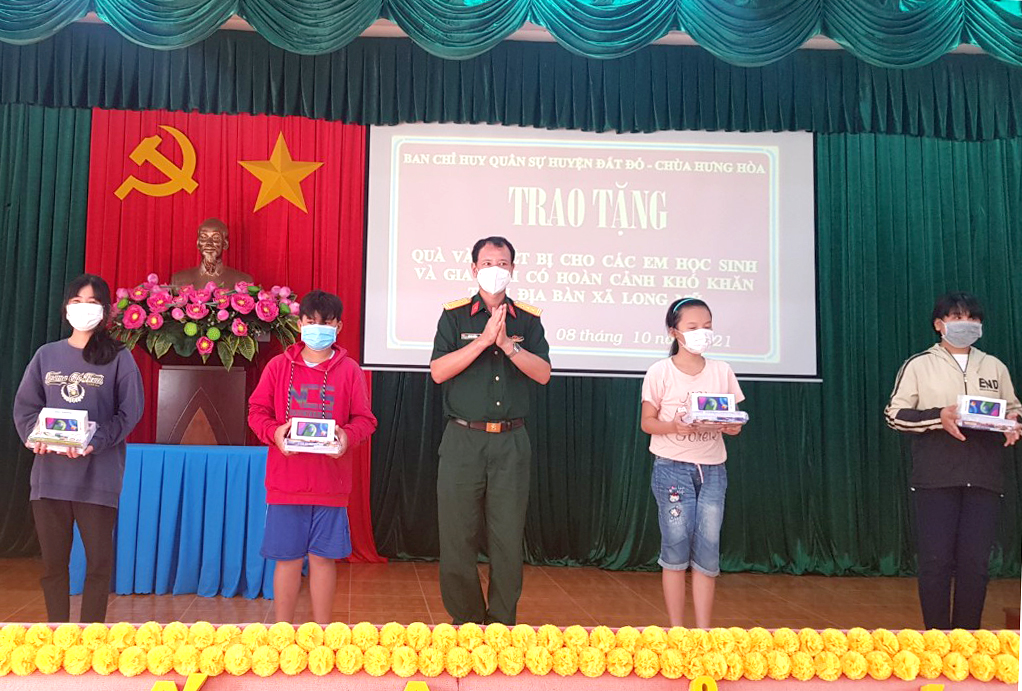Thượng tá Văn Bá Thắng, Chính trị viên Ban CHQS huyện Đất Đỏ trao điện thoại thông minh cho HS nghèo xã Long Mỹ.