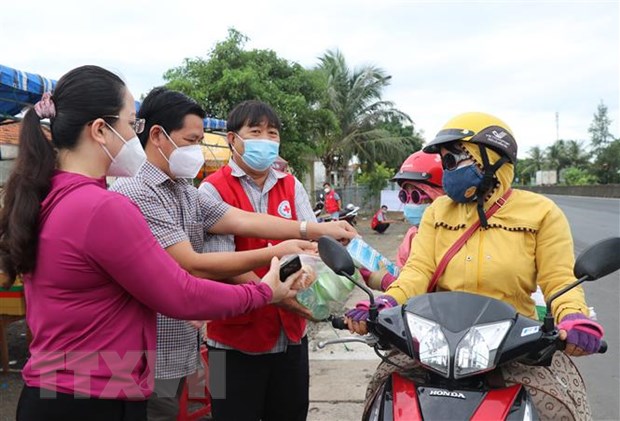 Người dân từ các tỉnh phía Nam về quê nhận hỗ trợ phần ăn, nước uống, sữa từ trạm dừng nghỉ Ga Hòa Đa, xã An Mỹ, huyện Tuy An, Phú Yên. Ảnh: TTXVN