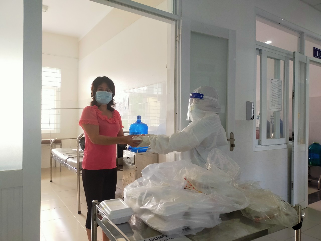 Nhân viên y tế tại cơ sở điều trị COVID-19 Trung tâm y tế huyện Long Điền phát cơm cho bệnh nhân.
