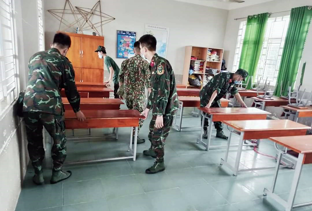 Cán bộ, chiến sĩ lực lượng vũ tranh huyện Long Điền sắp xếp lại bàn ghế HS tại Trường TH Nguyễn Bỉnh Khiêm (TT. Long Hải, huyện Long Điền).
