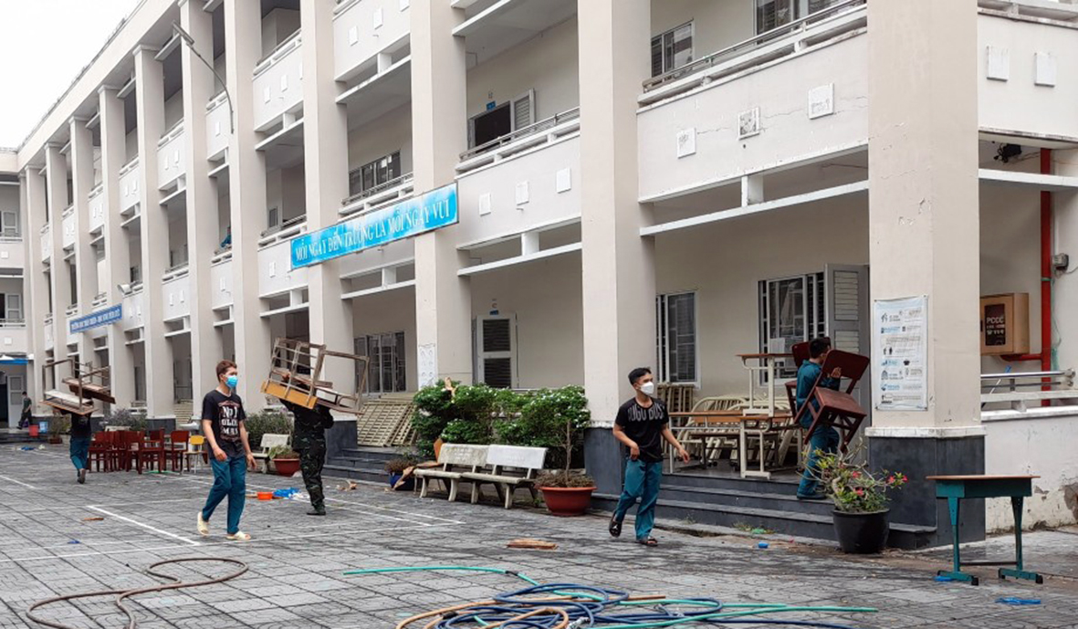 Cán bộ  chiến sĩ lực lượng vũ trang huyện Long Điền đưa và sắp xếp bàn ghế trong lớp học của Trường TH Cao Văn Ngọc ( xã An Ngãi).