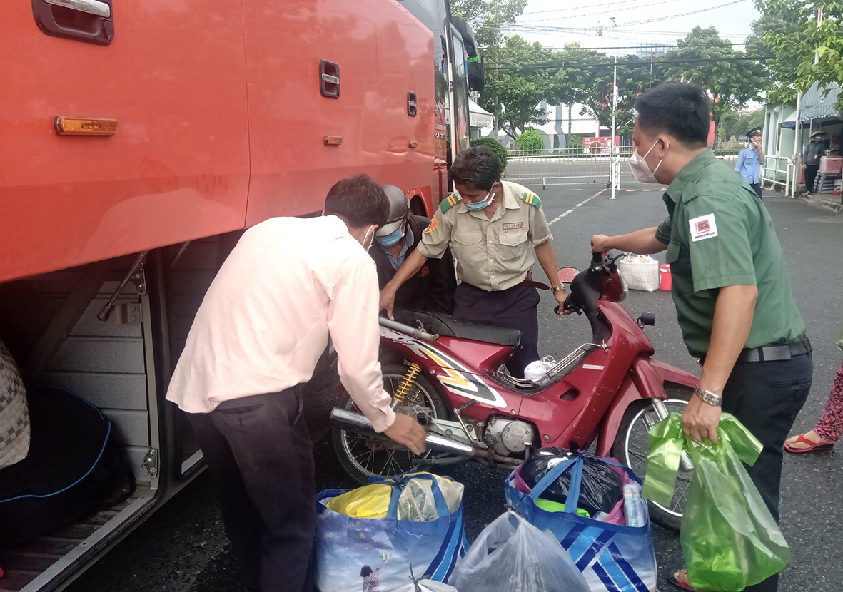 Nhân viên Tập đoàn Xe khách Phướng Trang chuyển xe máy, tư trang cho bà con lên xe.