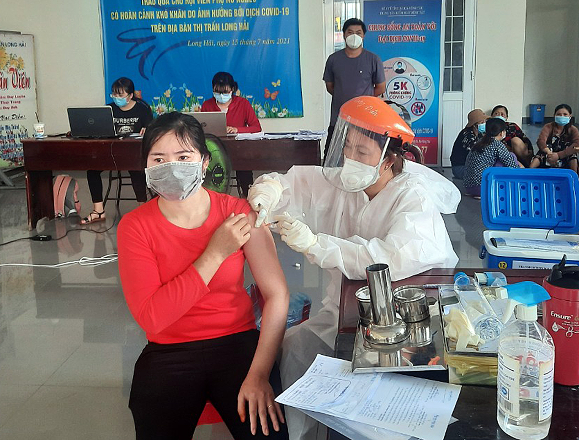 Nhân viên y tế tiêm vắc xin mũi 2 cho người dân thị trấn Long Hải vào sáng 21/10 tại điểm tiêm Trung tâm Văn hóa học tập cộng đồng thị trấn Long Hải. Ảnh: NGUYỄN TUYỀN