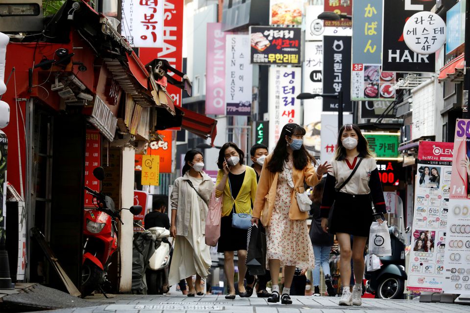 Người dân đeo khẩu trang đi bộ tại khu mua sắm Myeongdong ở Seoul (Hàn Quốc).