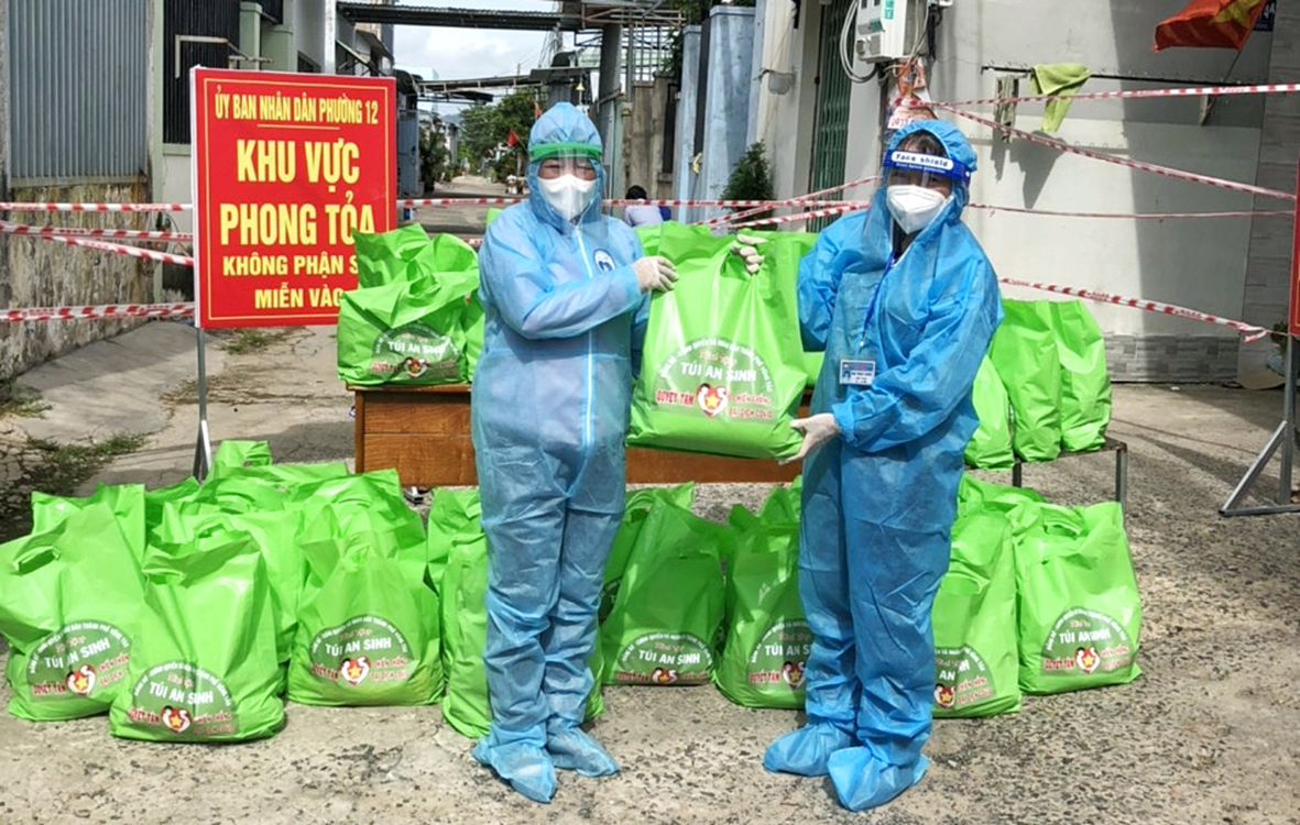 Đại diện UBMTTQ Việt Nam TP.Vũng Tàu (bên phải) trao tặng túi an sinh cho người dân trong khu phong tỏa tại phường 12.