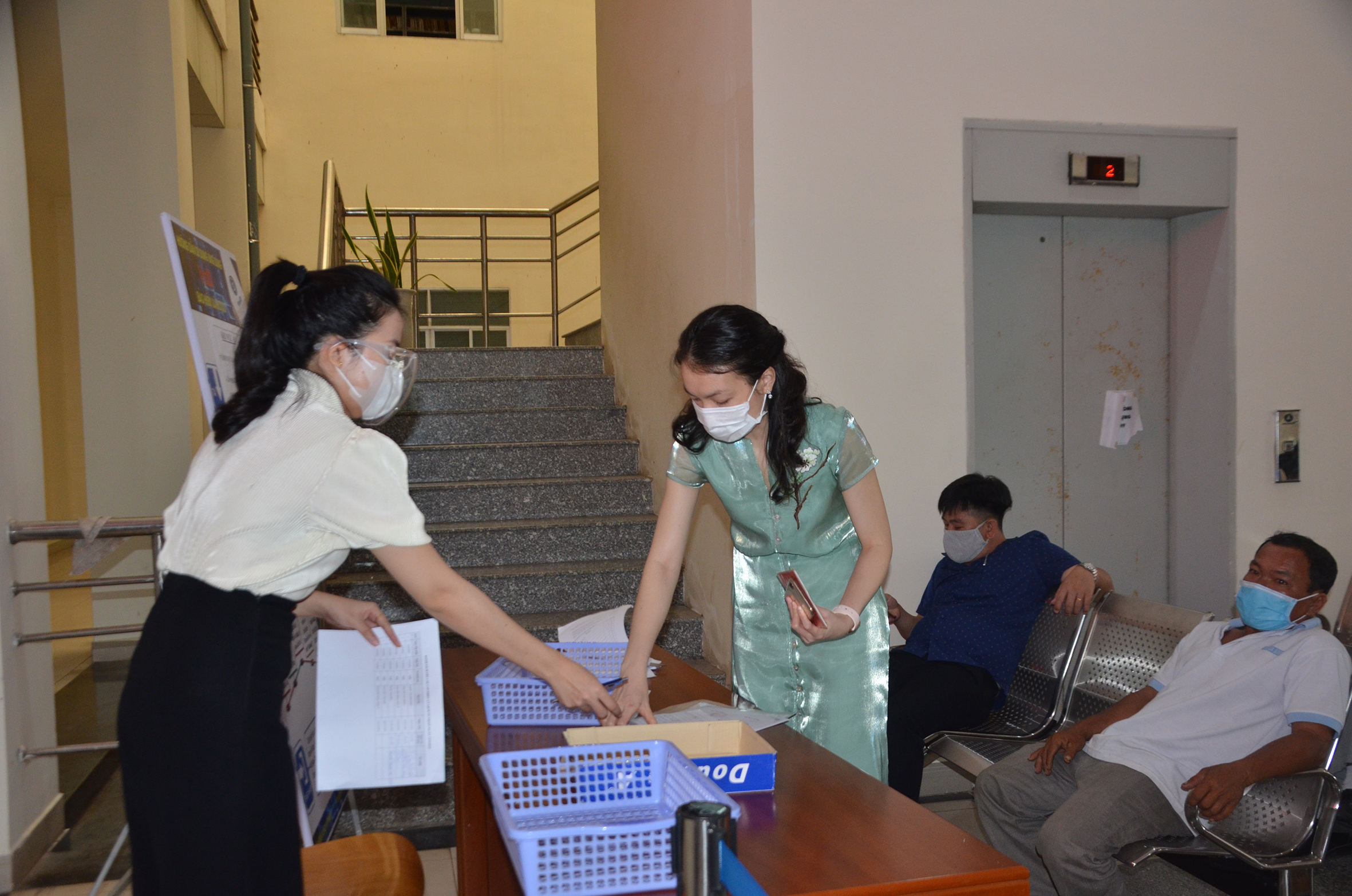Chị Vũ Anh Thư, chuyên viên Sở Tư pháp (trái) trả hồ sơ TTHC trực tiếp cho người dân sáng 9/11.
