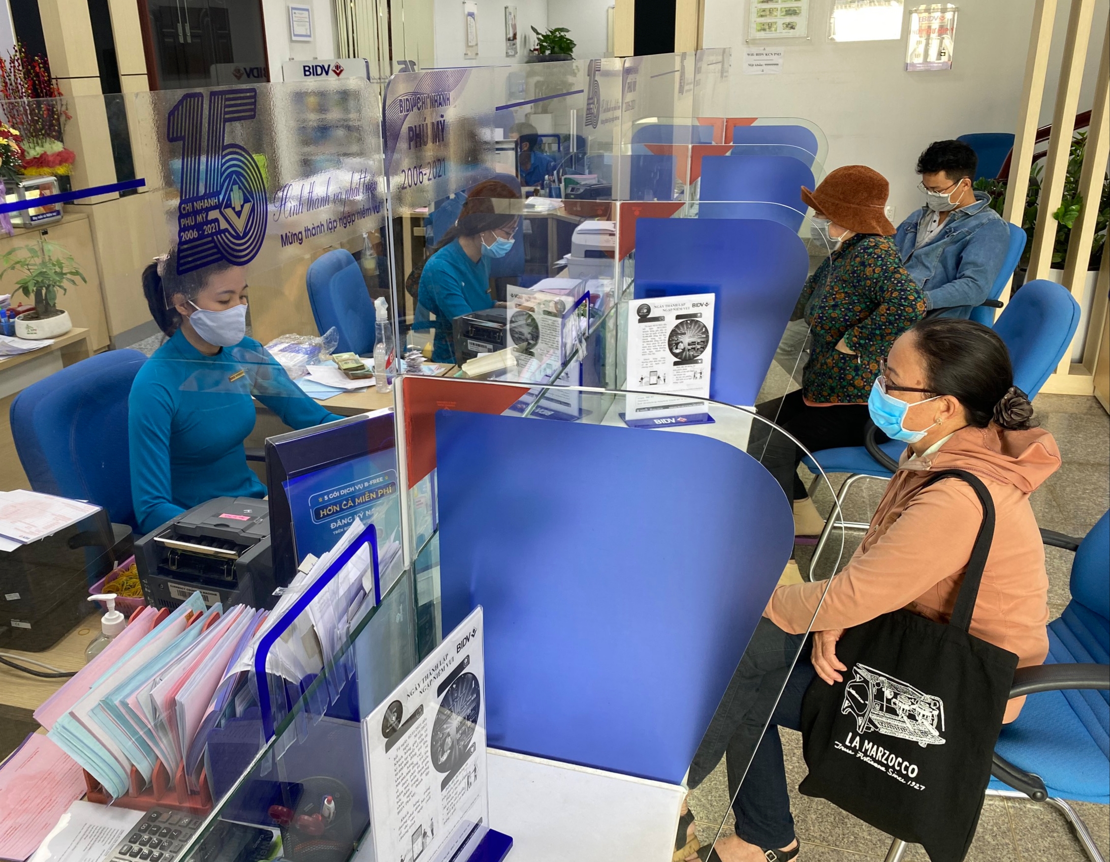 Tính đến đầu tháng 11/2021, tổng dư nợ đầu tư tín dụng cho các thành phần kinh tế tăng 11,89% so với cuối năm 2020. Trong ảnh: Khách hàng giao dịch tại BIDV Phú Mỹ.