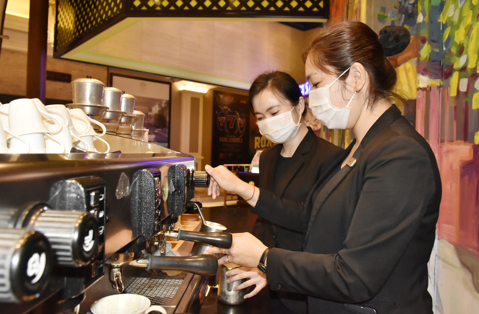 Trần Thị Yến Ngọc (bìa phải) pha chế cà phê tại The Grand Hồ Tràm Resort & Casino.