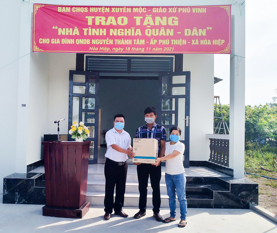 H2: Ông Lê Hồng Tuấn (bên trái), Phó Chủ tịch UBND xã Hòa Hiệp (huyện Xuyên Mộc) trao quà cho gia đình ông Nguyễn Thành Tâm tại Lễ bàn giao “Nhà tình nghĩa Quân – Dân”.