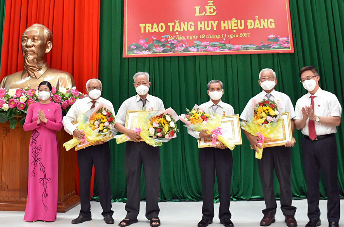 Ông Đặng Minh Thông, Ủy viên Ban thường vụ Tỉnh ủy, Bí thư Thành ủy Bà Rịa và bà Lê Thị Thủy, Phó Bí thư Thường trực Thành ủy Bà Rịa trao huy hiệu 50 năm tuổi Đảng cho các đảng viên.