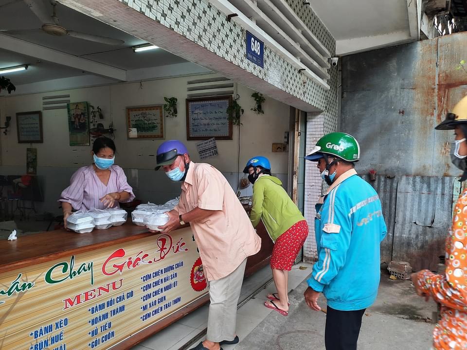 Người dân khó khăn nhận cơm tại bếp ăn tình thương của Tịnh Xá Ngọc Đức.