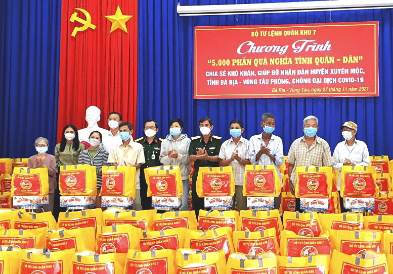 Đại diện Bộ Tư lệnh Quân khu 7 và Bộ CHQS tỉnh trao quà cho các hộ dân có hoàn cảnh khó khăn do ảnh hưởng của dịch COVID-19.