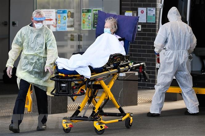 Nhân viên y tế chuyển bệnh nhân COVID-19 tại Melbourne (Australia).