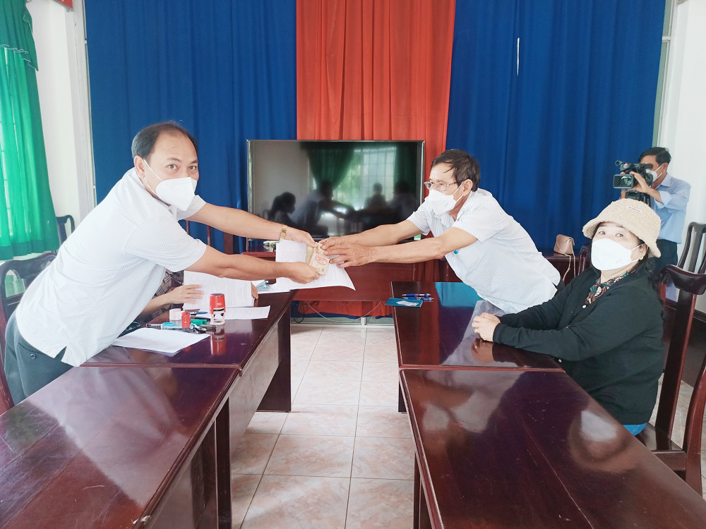 Ban điều hành Quỹ hỗ trợ nông dân tỉnh trao tiền cho hội viên vay vốn.