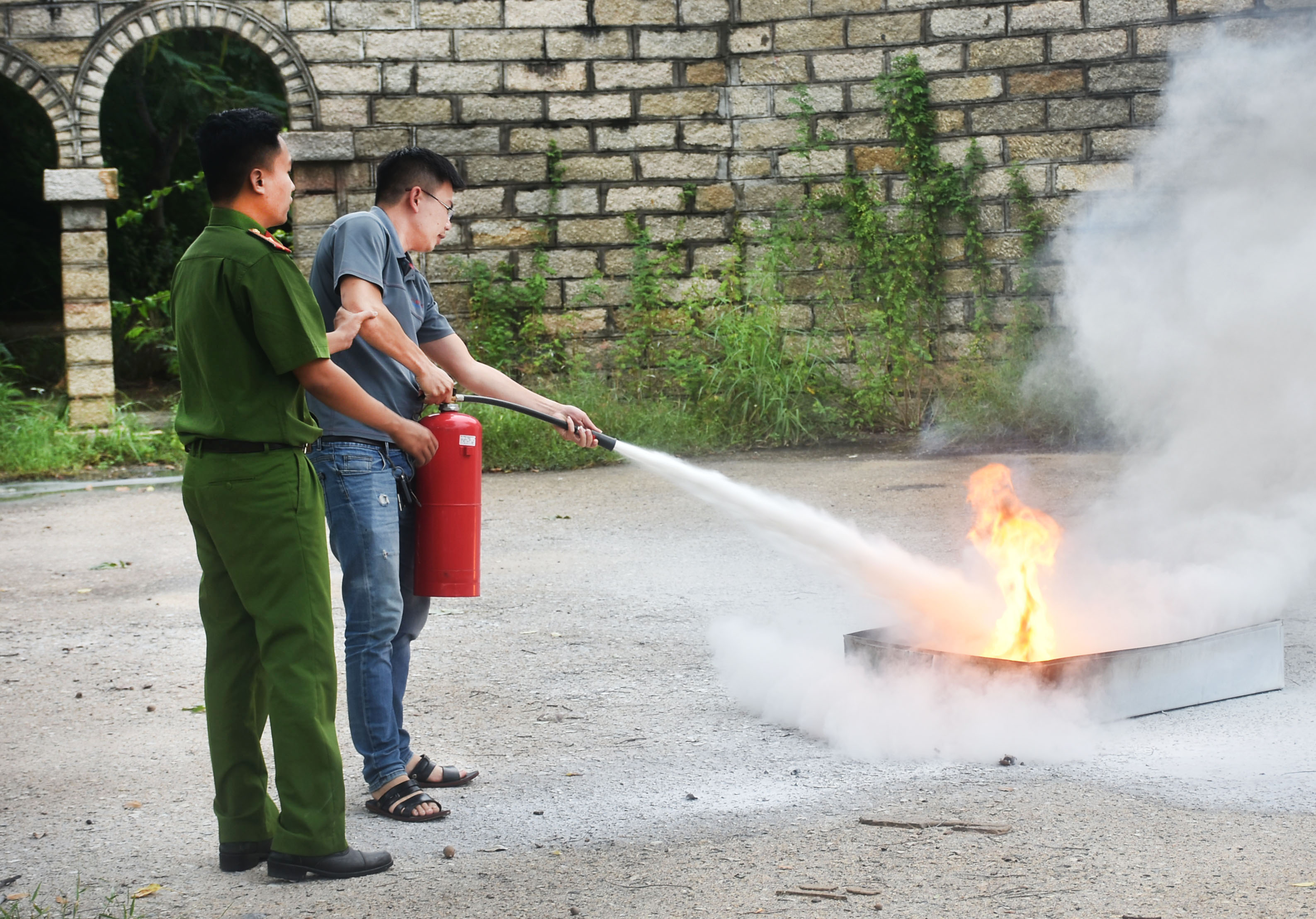 Lực lượng Cảnh sát PCCC và CNCH-Công an tỉnh hướng dẫn người dân cách sử dụng bình cứu hỏa.
