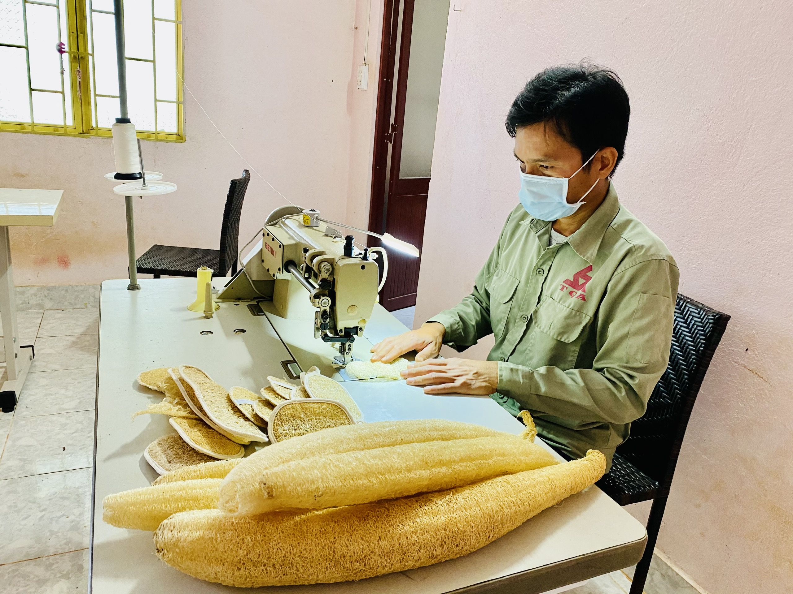 Anh Phạm Văn Đoàn may các sản phẩm từ xơ mướp.