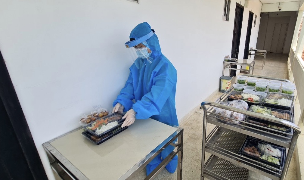 Nhân viên khách sạn Hoa Phượng Đỏ phục vụ suất ăn tại phòng cho khách cách ly. (Ảnh chụp tháng 8/2021)