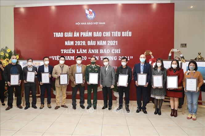 Ông Lê Quốc Minh, Chủ tịch Hội Nhà báo Việt Nam, Tổng Biên tập Báo Nhân Dân trao giải A Giải thưởng Bìa báo Tết ấn tượng năm 2021 cho các đơn vị đoạt giải. Ảnh: TTXVN