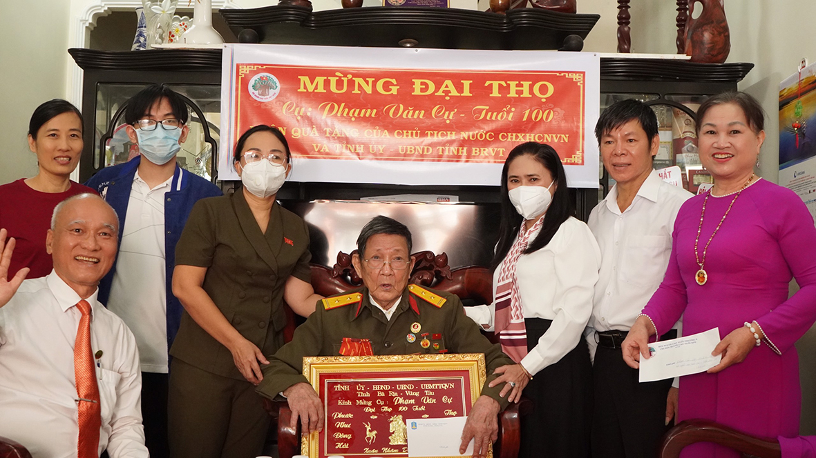 Bà Đinh Thị Trúc Mỹ, Phó Giám đốc Sở LĐTBXH (thứ ba, từ phải qua) tặng quà chúc thọ cụ Phạm Văn Cự.