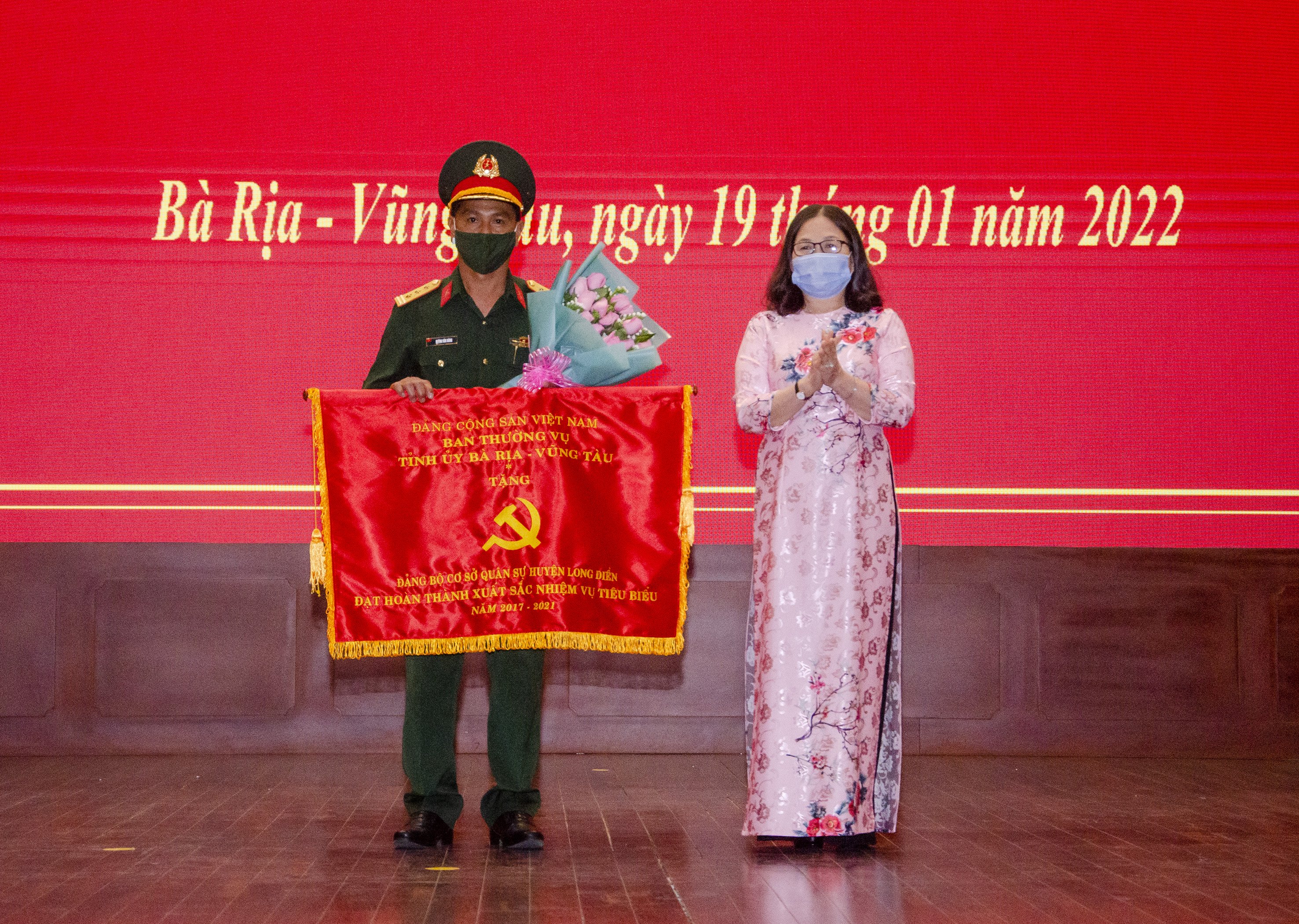 Bà Nguyễn Thị Yến, Phó Bí thư Thường trực Tỉnh ủy, Trưởng Đoàn ĐBQH tỉnh trao Cờ Thi đua cho Đảng bộ cơ sở Quân sự huyện Long Điền vì có thành tích “Hoàn thành xuất sắc nhiệm vụ tiêu biểu” 5 năm liền (2017-2021).