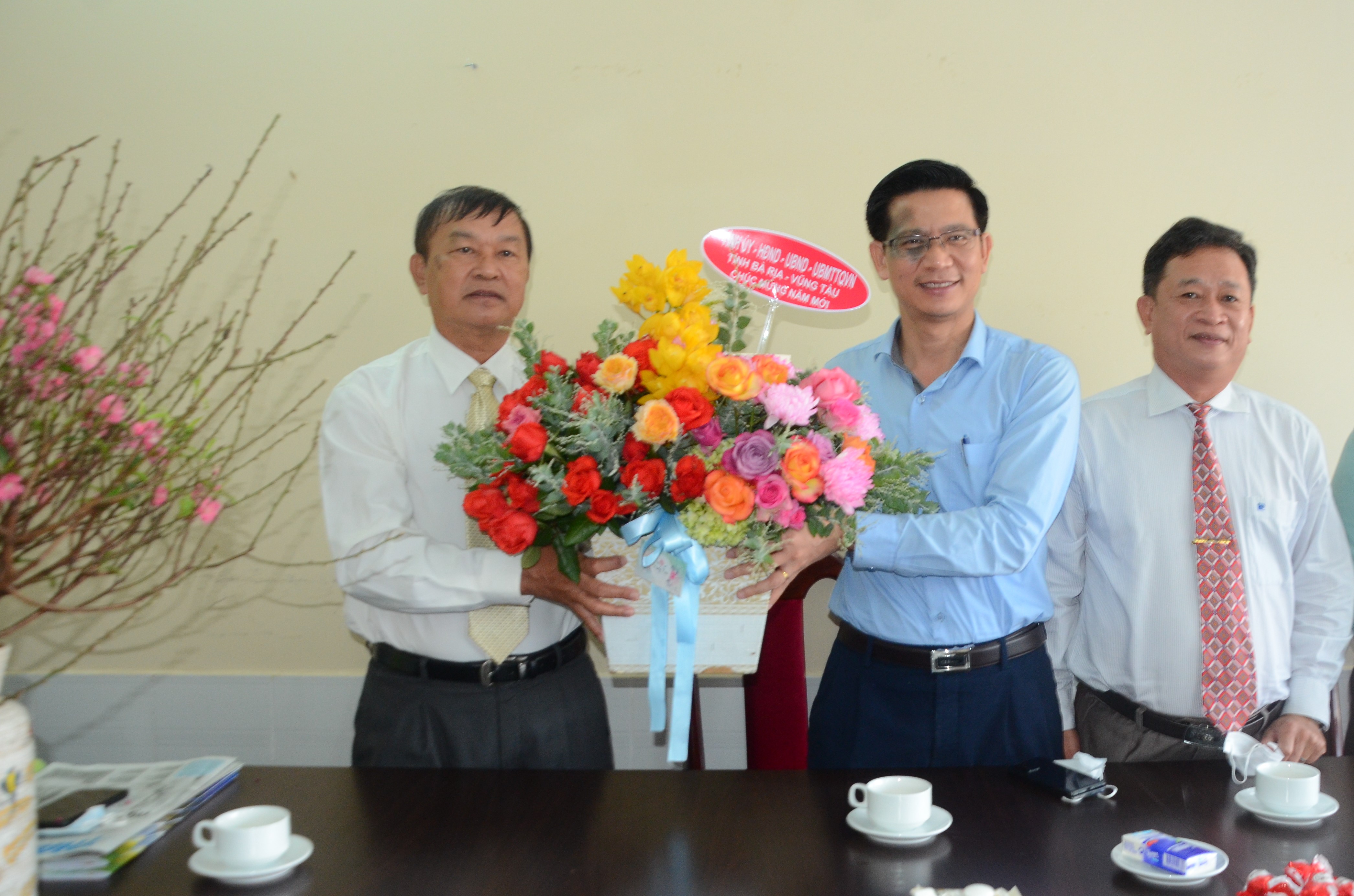Ông Lê Văn Tuấn, Giám đốc Sở TT-TT (giữa) và ông Lê Văn Lâm, Phó Trưởng Ban Tuyên giáo Tỉnh ủy (phải) tặng hoa chúc Tết Hội Nhà báo tỉnh. Ảnh: CẨM NHUNG