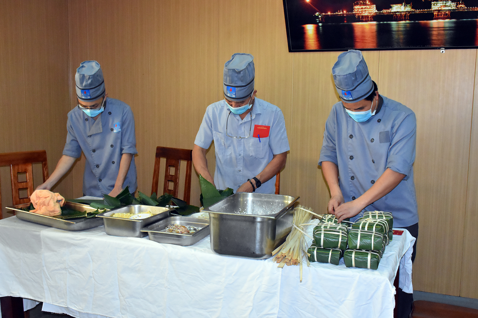 Ông Phạm Văn Tự và các đồng nghiệp gói bánh chưng để cán bộ, kỹ sư, người lao động trên Giàn CNTT 3 đón Tết.