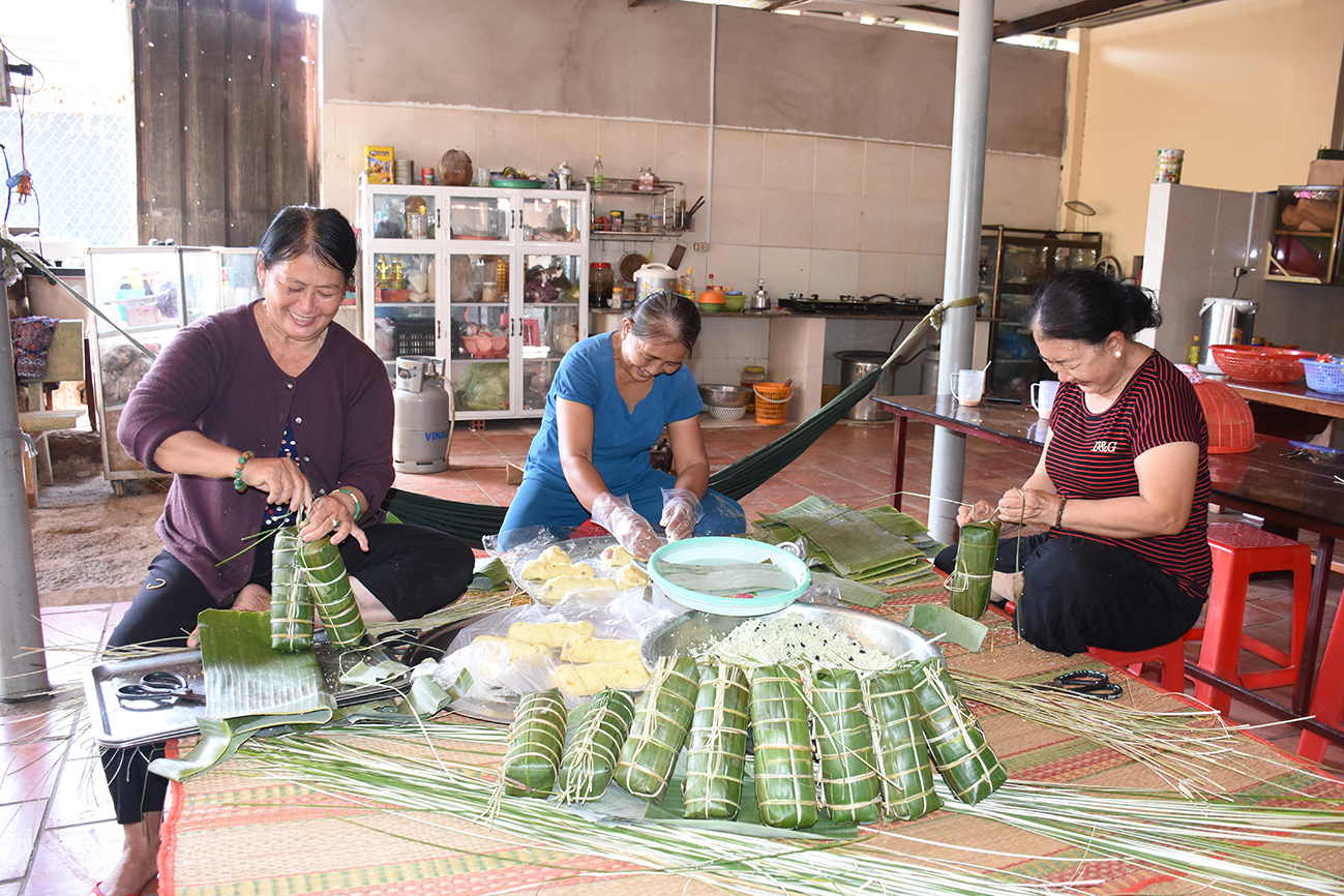 Các cô ở khu phố Thanh Long, thị trấn Đất Đỏ, huyện Đất Đỏ gói bánh tét để giao cho khách ăn Tết.
