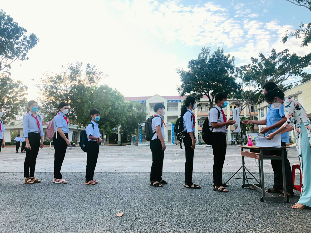 học sinh trường THCS Nguyễn Công Trứ (thị trấn Long Hải, huyện Long Điền) xếp hàng rửa tay sát khuẩn trước khí vào lớp học. Ảnh: NGUYỄN TUYỀN