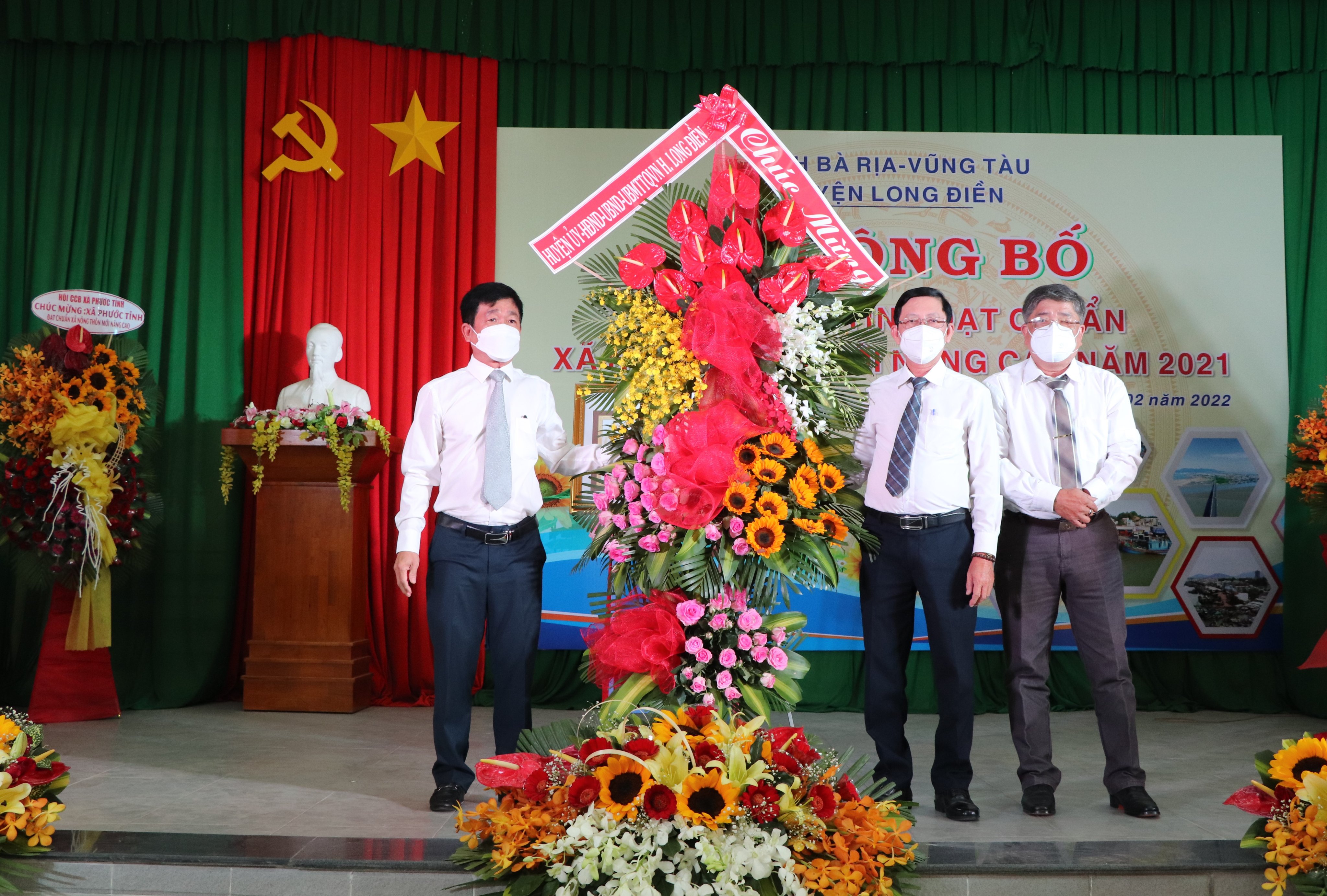 Ông Trần Kim Phúc, Phó Chủ tịch UBND huyện Long Điền tặng hoa chúc mừng xã Phước Tỉnh được công nhận đạt chuẩn NTM nâng cao. 